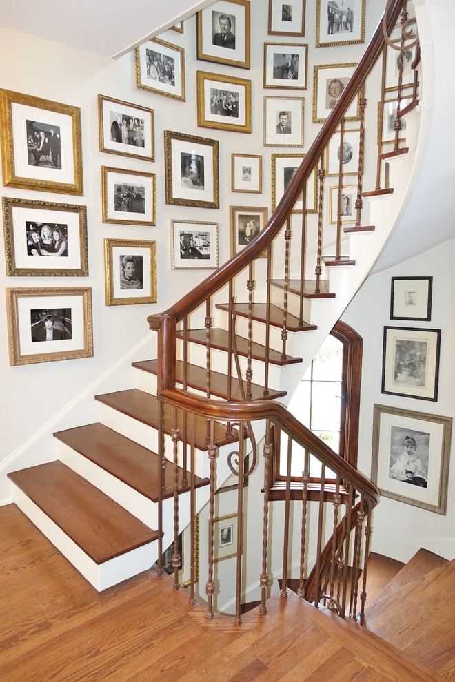 Foto de escalera curva clásica de tamaño medio con escalones de madera y contrahuellas de madera pintada