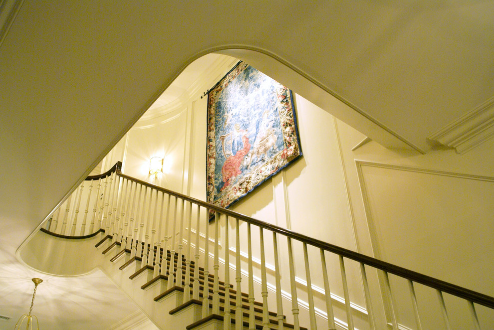 На фото: большая прямая лестница в классическом стиле с деревянными ступенями, крашенными деревянными подступенками и деревянными перилами с