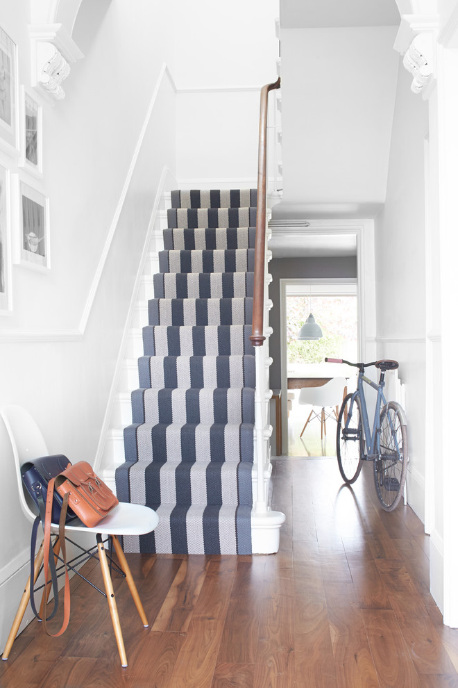 Cette image montre un escalier peint traditionnel en U avec des marches en bois peint.