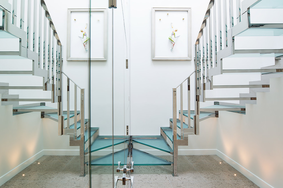 На фото: изогнутая лестница в современном стиле с стеклянными ступенями без подступенок с