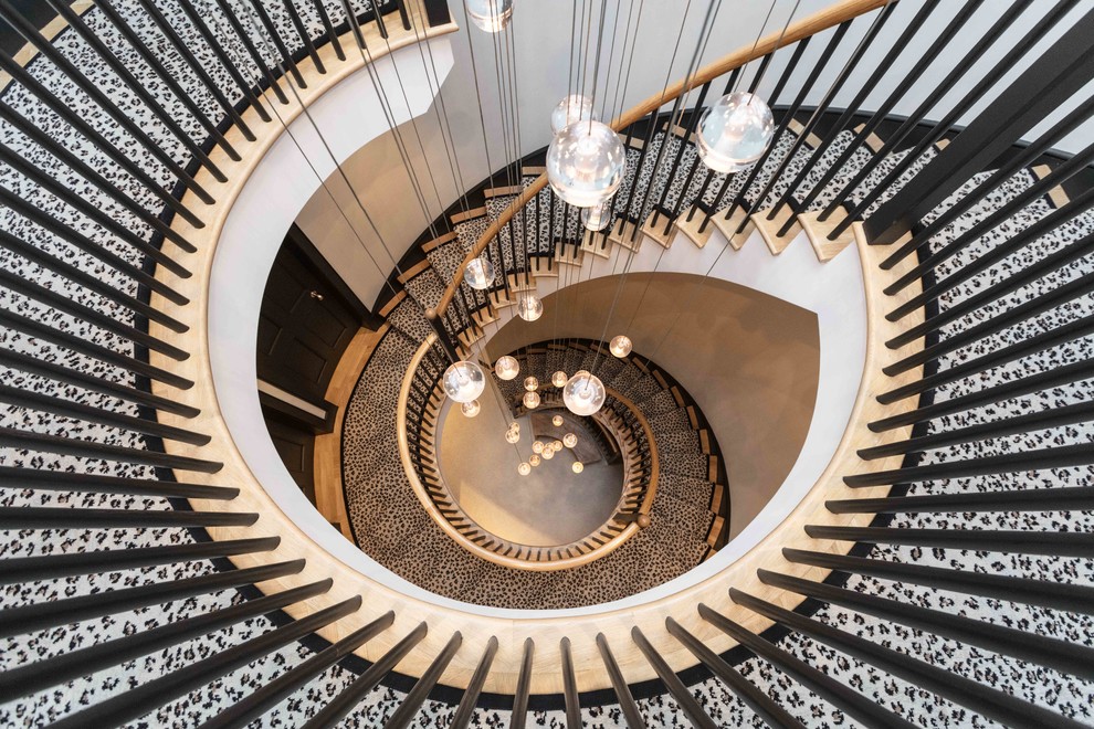 Стильный дизайн: винтовая лестница в современном стиле с ступенями с ковровым покрытием, ковровыми подступенками и деревянными перилами - последний тренд