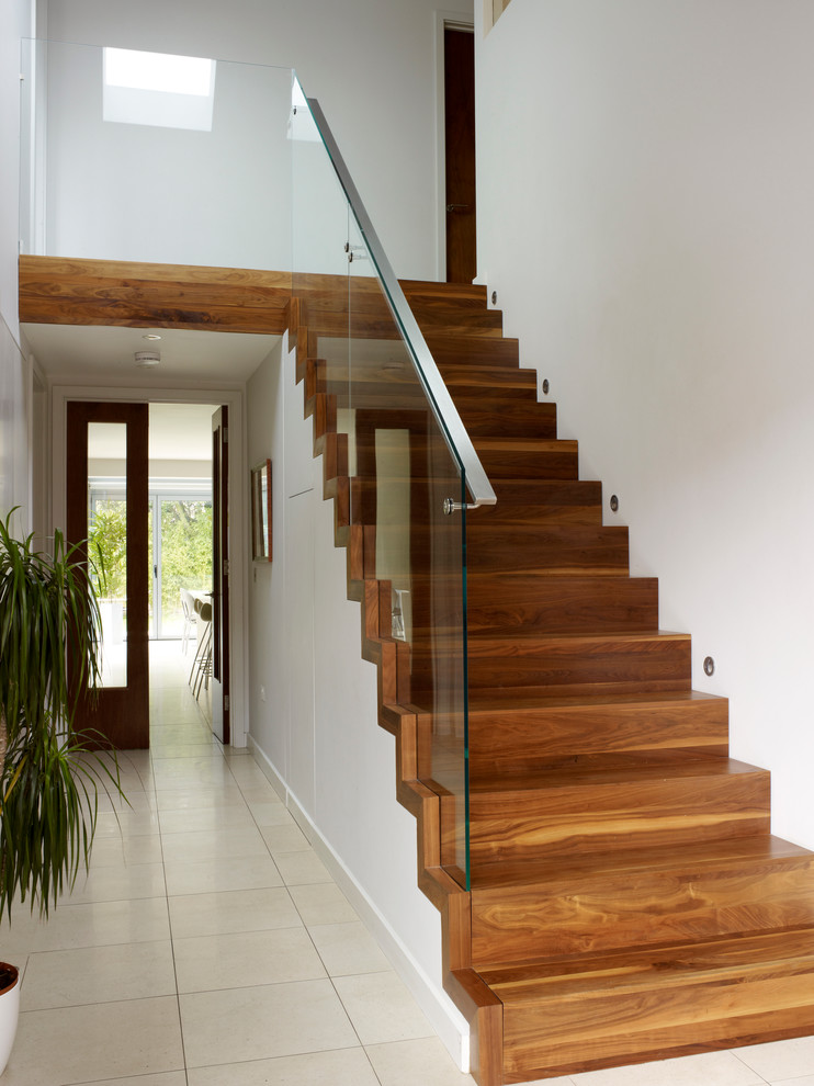 Photo of a medium sized contemporary wood straight staircase in London with wood risers.