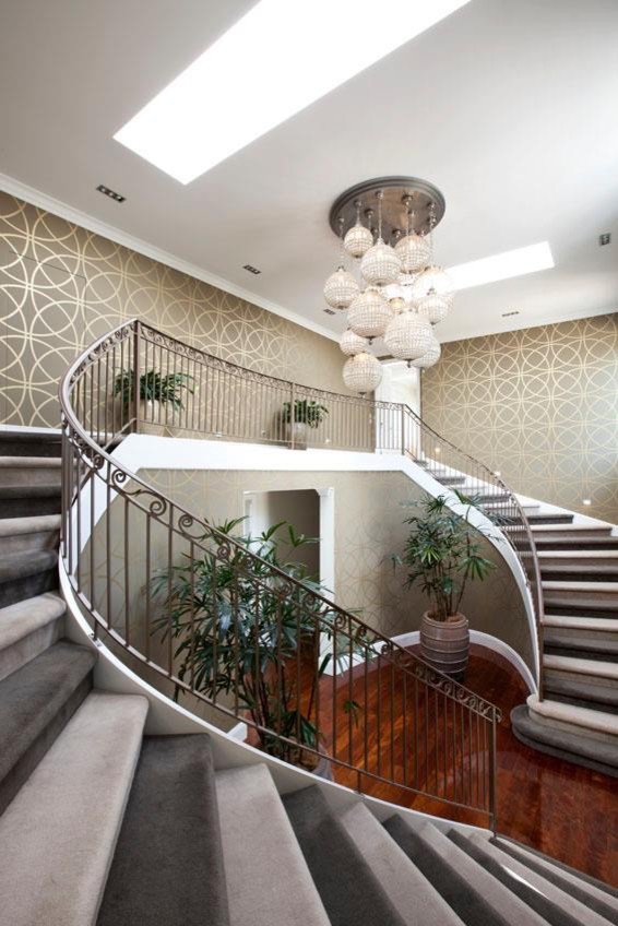 Cette photo montre un grand escalier courbe tendance avec des marches en moquette et des contremarches en moquette.