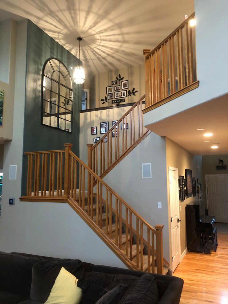 Large traditional carpeted u-shaped wood railing staircase in Denver with carpeted risers.