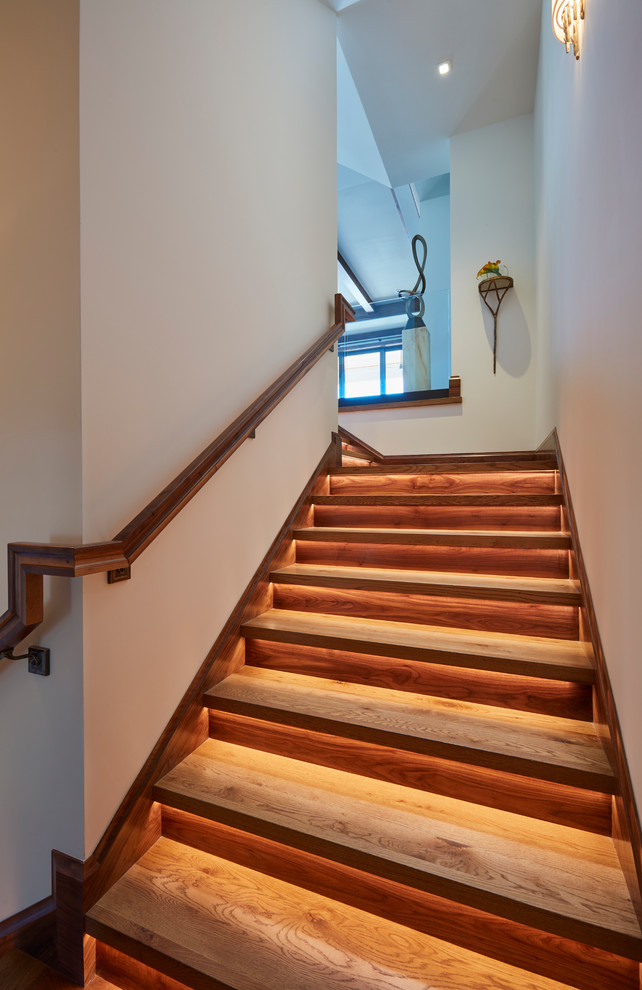 Ejemplo de escalera en L exótica de tamaño medio con escalones de madera, contrahuellas de madera y barandilla de madera