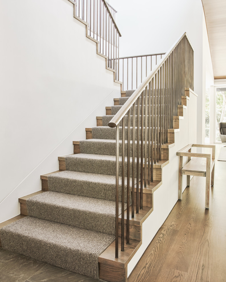 Expansive wood straight metal railing staircase in Los Angeles with wood risers.