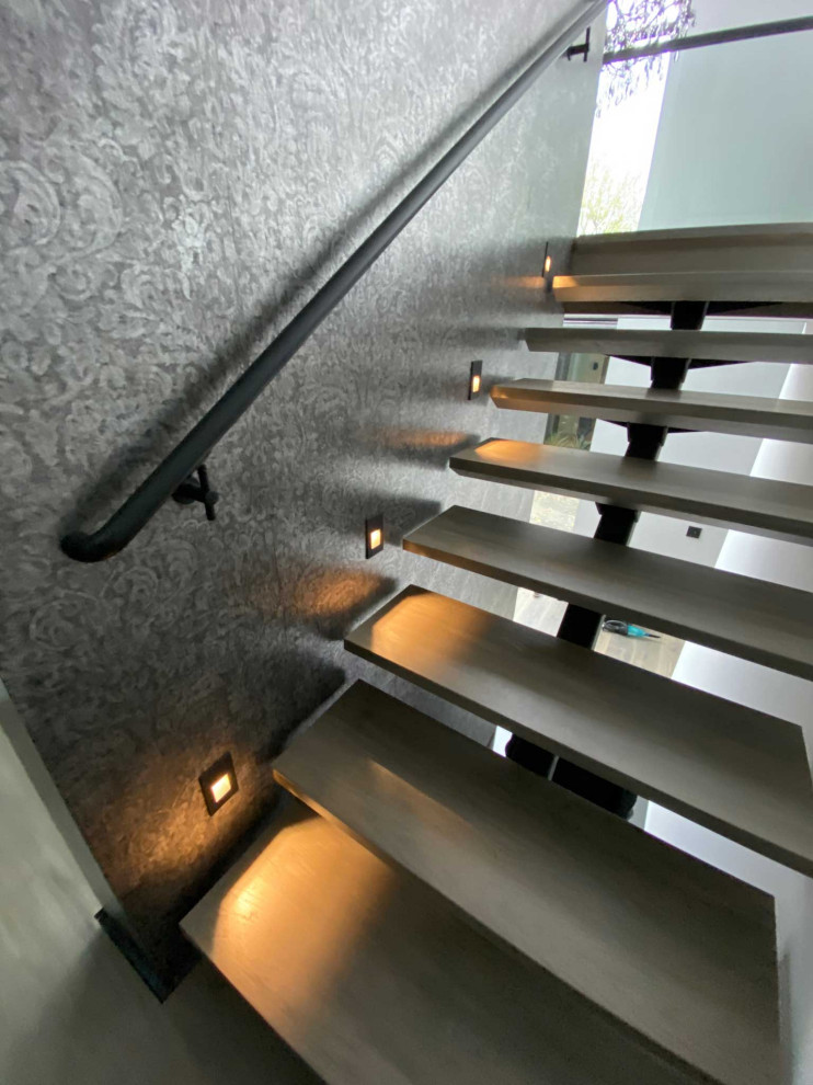 Ejemplo de escalera suspendida contemporánea de tamaño medio sin contrahuella con escalones de madera y barandilla de madera