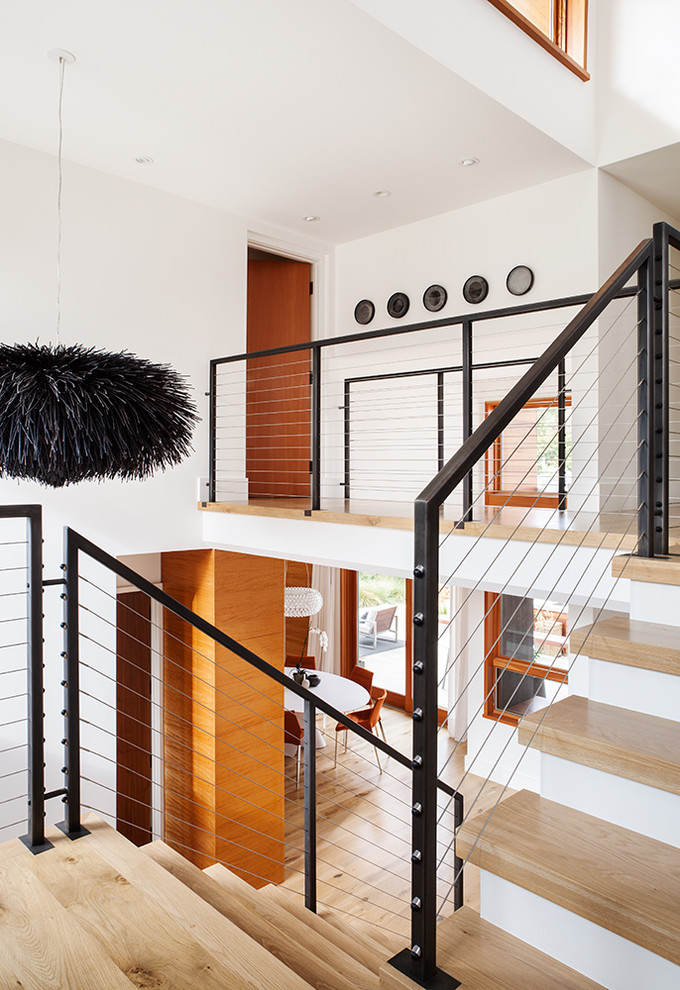 Пример оригинального дизайна: угловая деревянная лестница среднего размера в современном стиле с деревянными ступенями и металлическими перилами