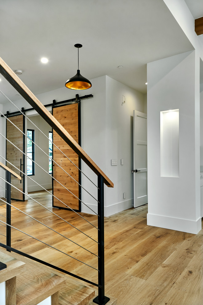 Ejemplo de escalera en L minimalista de tamaño medio con escalones de madera, contrahuellas de madera y barandilla de cable