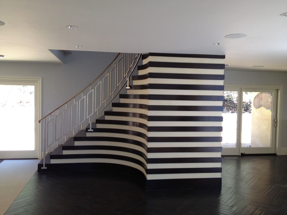 На фото: изогнутая лестница в стиле модернизм с деревянными ступенями с
