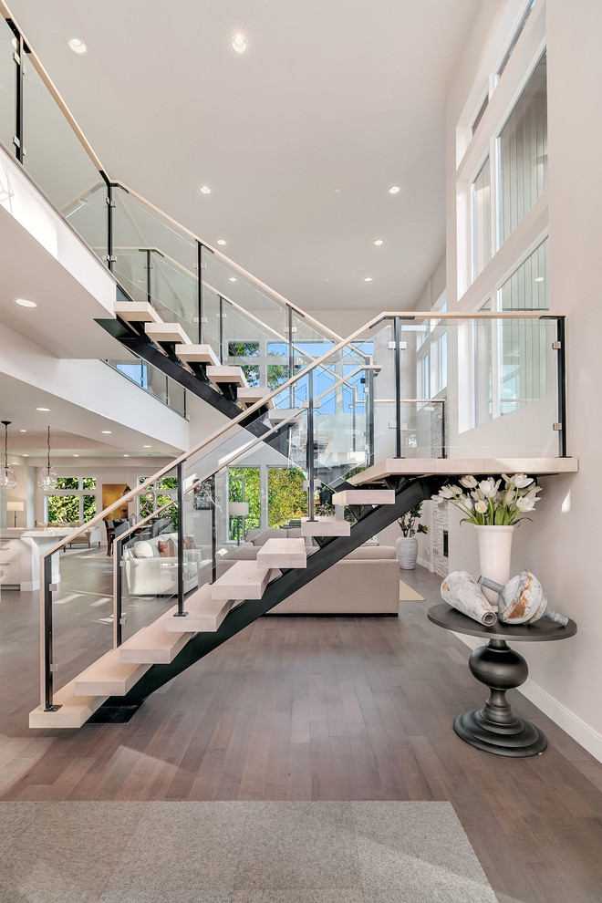 Inspiration pour un escalier sans contremarche design en U avec des marches en bois et un garde-corps en verre.