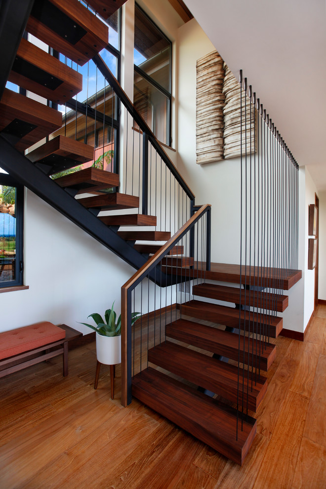 Diseño de escalera suspendida tropical grande sin contrahuella con escalones de madera y barandilla de cable