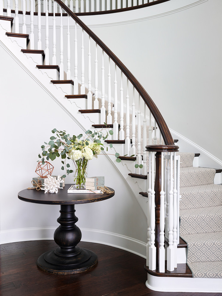 Стильный дизайн: изогнутая лестница в классическом стиле с деревянными ступенями и крашенными деревянными подступенками - последний тренд