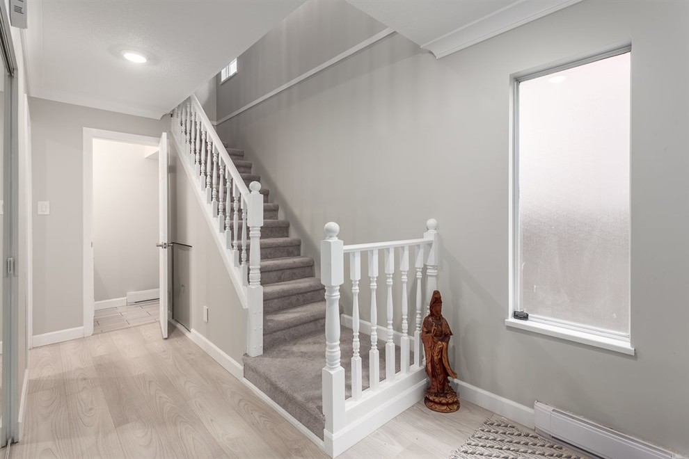 Mid-sized transitional carpeted l-shaped wood railing staircase photo in Vancouver with carpeted risers