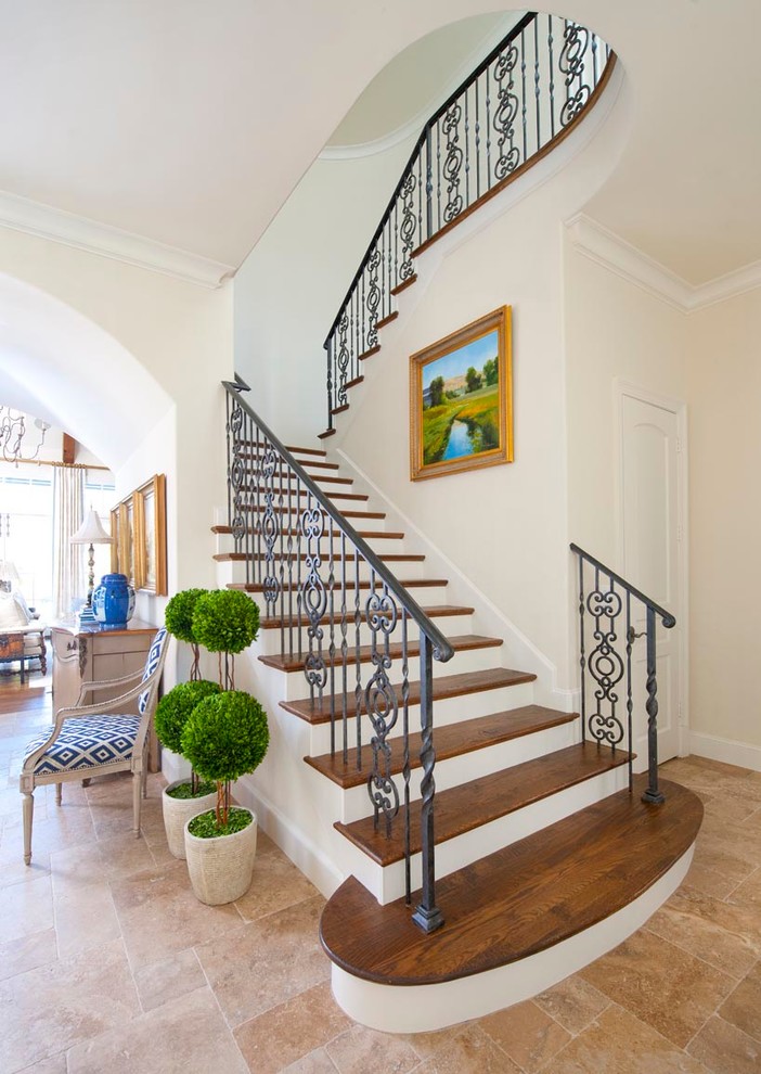 This is an example of a traditional wood u-shaped metal railing staircase in Dallas with painted wood risers and feature lighting.