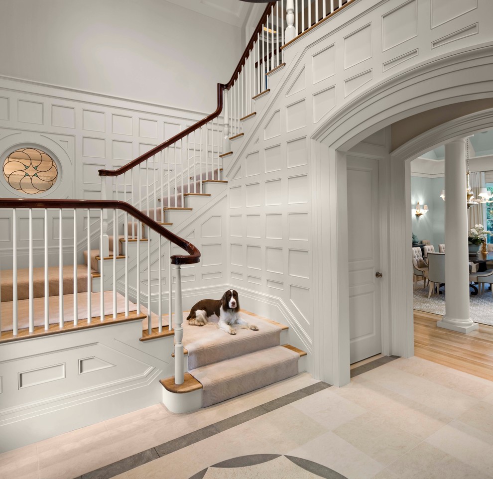 Imagen de escalera en L clásica renovada grande con escalones de madera, contrahuellas de madera pintada y barandilla de madera