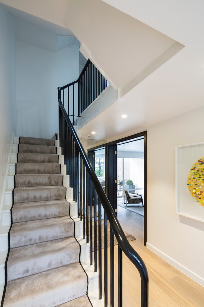 Gerade, Mittelgroße Moderne Treppe mit gebeizten Holz-Treppenstufen und Teppich-Setzstufen in London