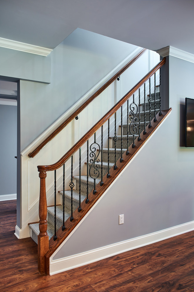 Foto de escalera recta clásica con escalones enmoquetados, barandilla de varios materiales y panelado