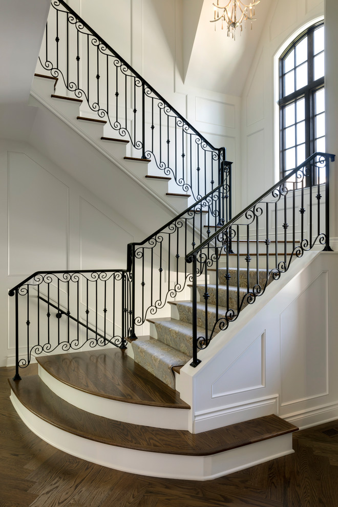 Example of a classic wooden u-shaped metal railing staircase design with carpeted risers