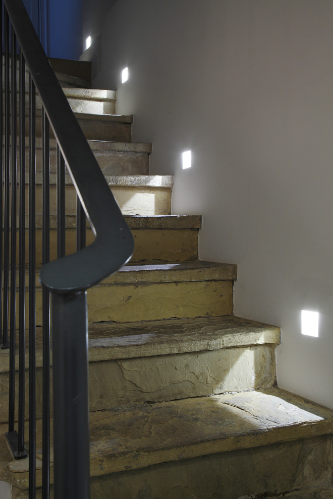 ロンドンにある高級な広いトラディショナルスタイルのおしゃれな直階段 (ライムストーンの蹴込み板、金属の手すり) の写真