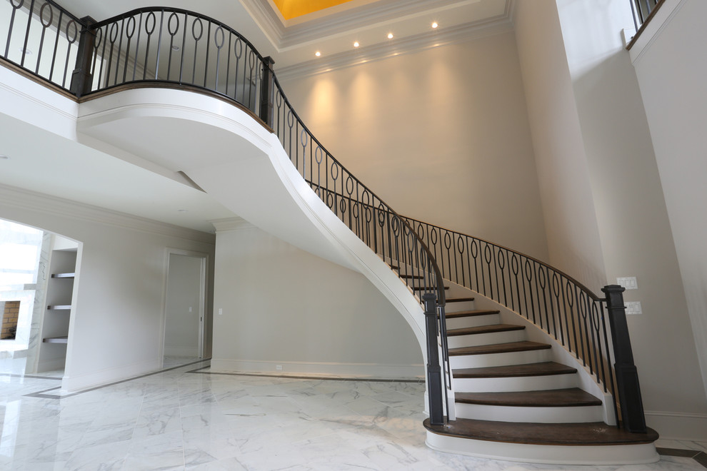 Свежая идея для дизайна: большая изогнутая лестница в современном стиле с деревянными ступенями и крашенными деревянными подступенками - отличное фото интерьера