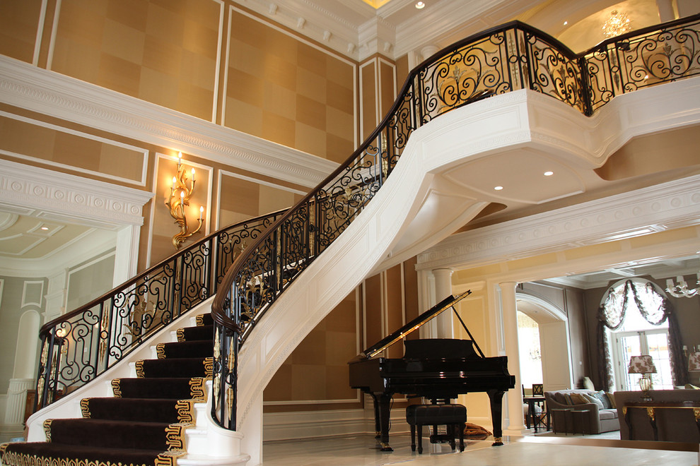 Стильный дизайн: большая изогнутая лестница в средиземноморском стиле с крашенными деревянными ступенями и крашенными деревянными подступенками - последний тренд
