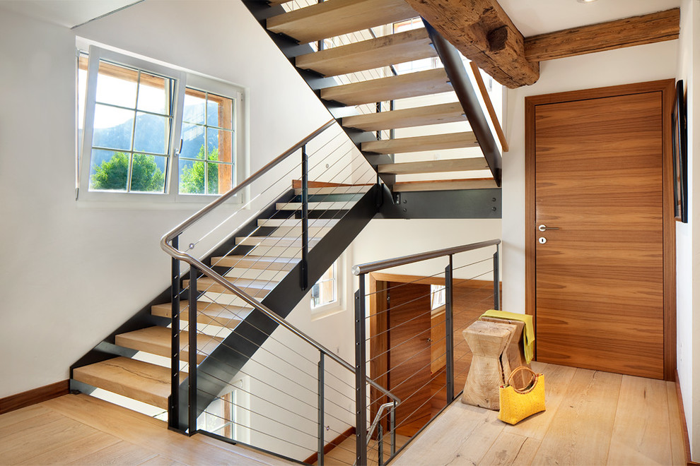 Inspiration for a large rustic wooden floating staircase remodel in Denver with metal risers