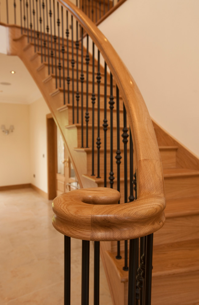Foto de escalera curva actual grande con escalones de madera y contrahuellas de madera
