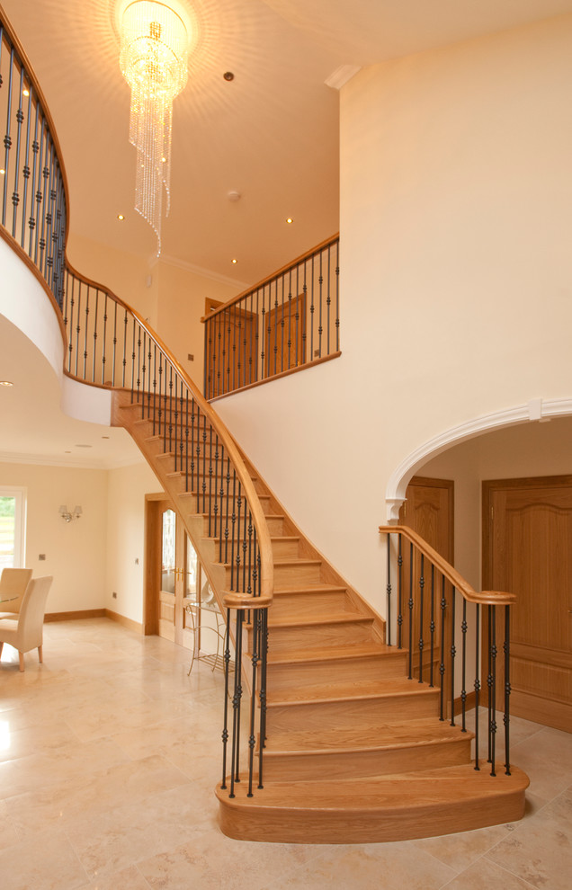 Photo of a large contemporary wood curved staircase in Other with wood risers.