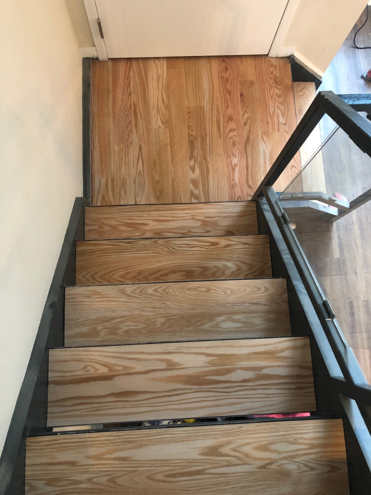 Foto de escalera recta tradicional de tamaño medio sin contrahuella con escalones de madera y barandilla de metal