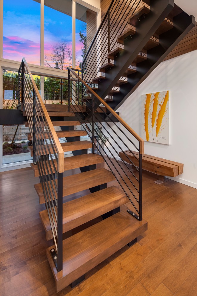 Exemple d'un escalier flottant tendance avec des marches en bois, des contremarches en métal et un garde-corps en métal.