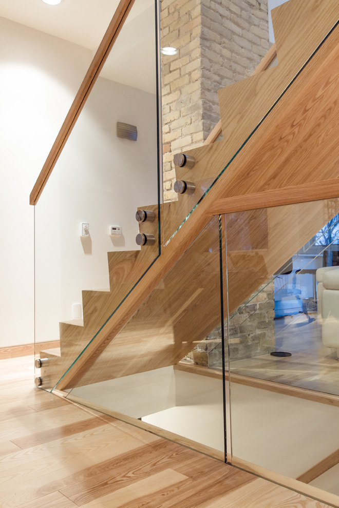 На фото: большая деревянная лестница в стиле модернизм с деревянными ступенями и стеклянными перилами с
