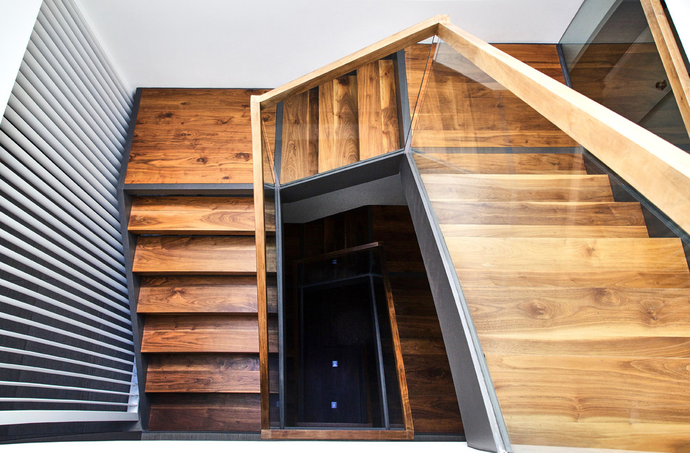 Стильный дизайн: лестница на больцах, среднего размера в стиле модернизм с деревянными ступенями - последний тренд