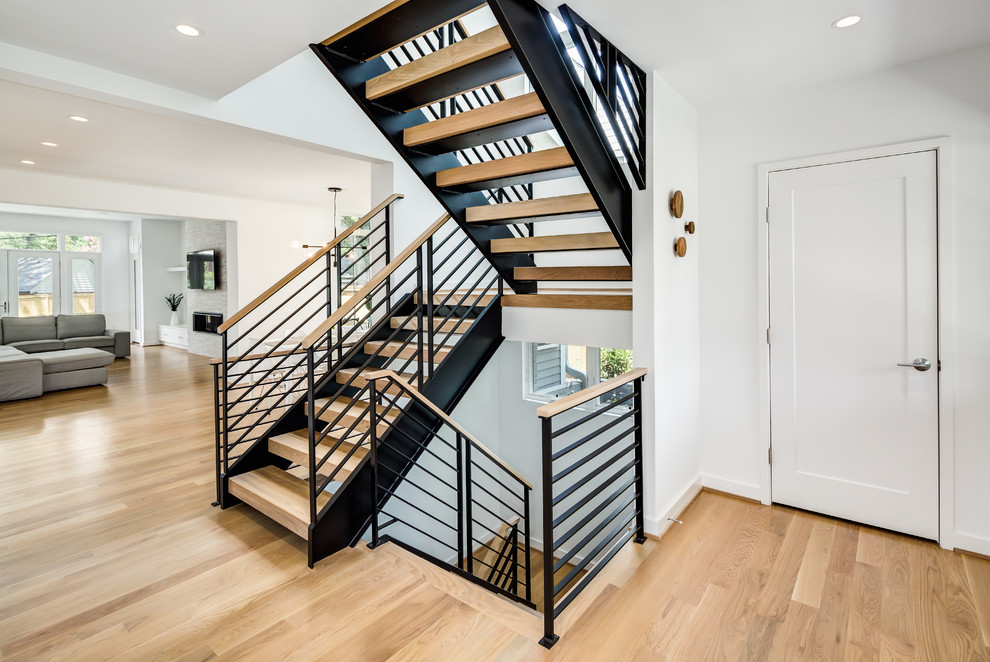 Пример оригинального дизайна: большая п-образная лестница в современном стиле с деревянными ступенями и перилами из смешанных материалов без подступенок