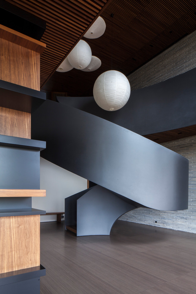 Источник вдохновения для домашнего уюта: огромная винтовая бетонная лестница в стиле модернизм с деревянными ступенями