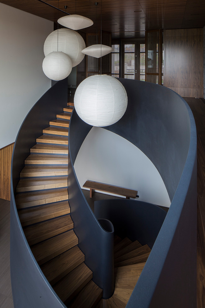 Expansive modern wood spiral staircase in San Francisco with concrete risers.