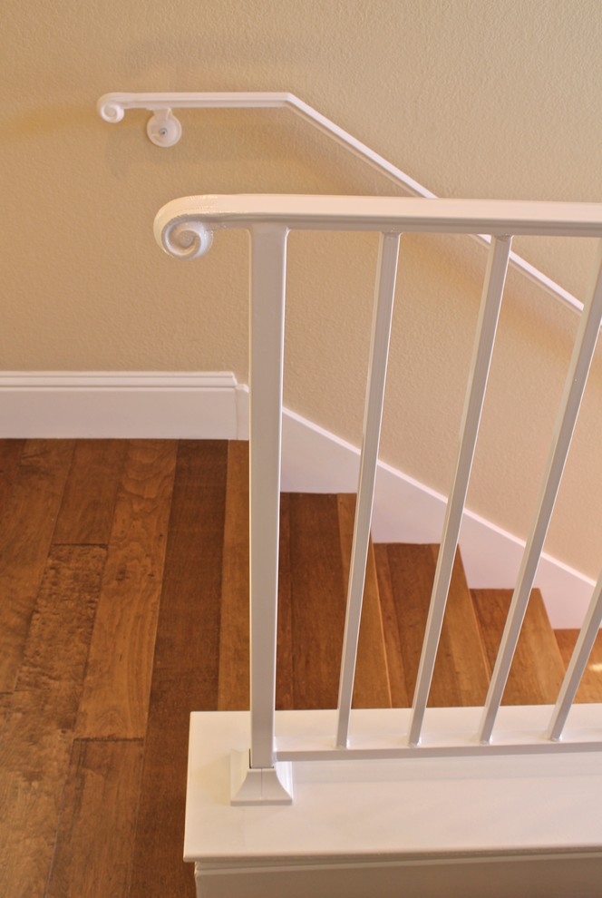 Ejemplo de escalera recta contemporánea pequeña con escalones de madera, contrahuellas de madera y barandilla de metal