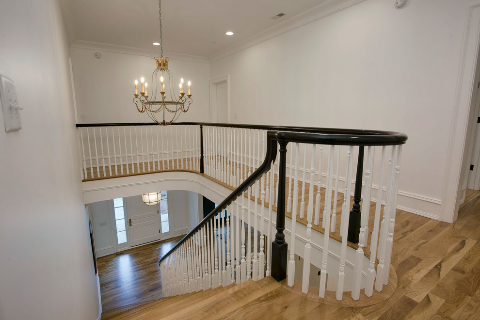 Imagen de escalera recta clásica con contrahuellas de madera pintada y barandilla de madera