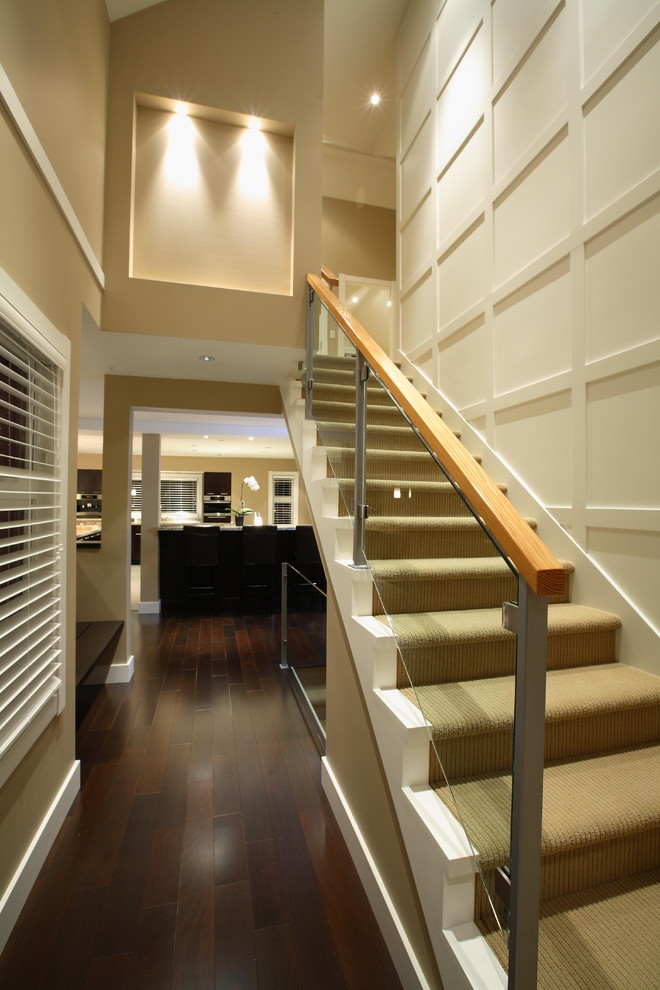 Стильный дизайн: большая прямая лестница в стиле неоклассика (современная классика) с стеклянными перилами, крашенными деревянными ступенями и крашенными деревянными подступенками - последний тренд