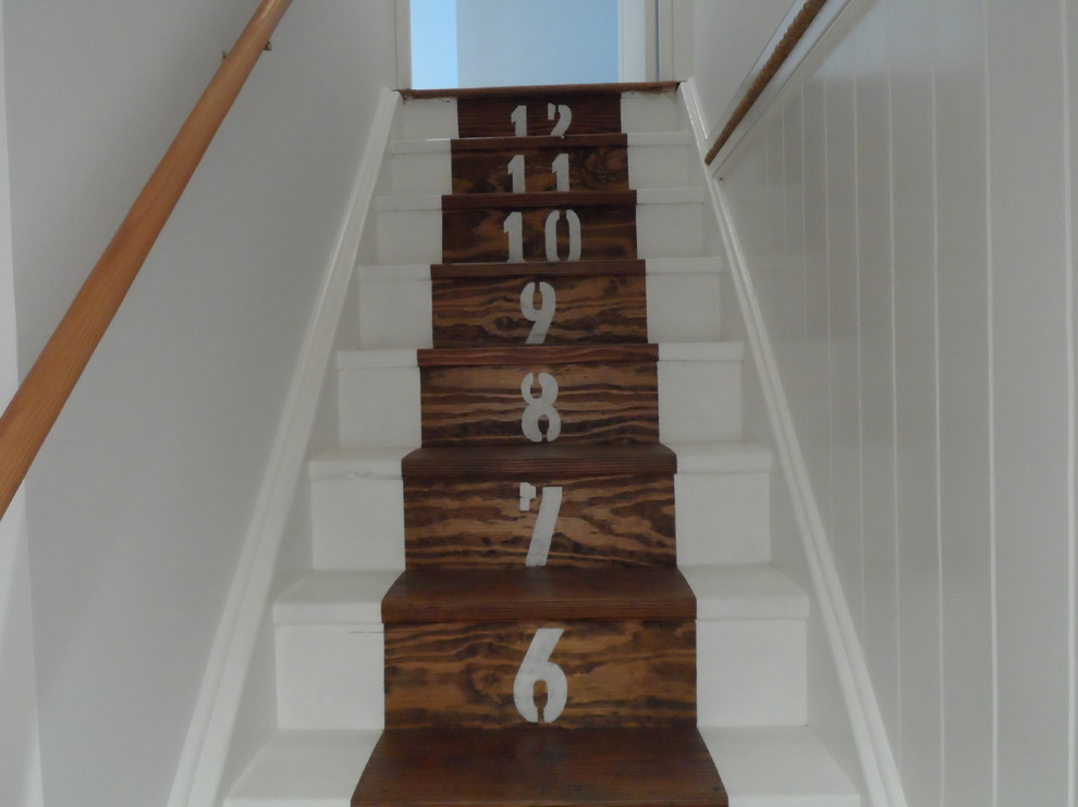 Example of a beach style painted straight staircase design in New York with painted risers