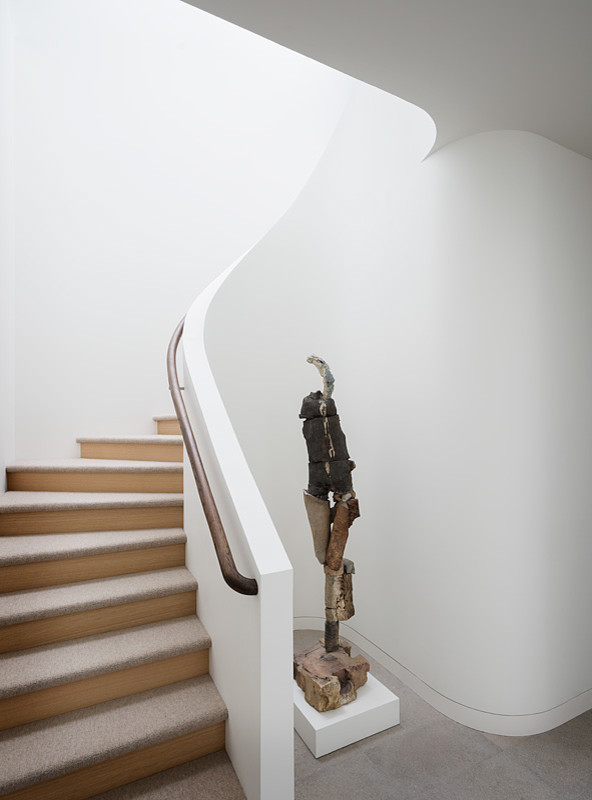 Idées déco pour un escalier courbe moderne de taille moyenne avec des marches en moquette et des contremarches en bois.