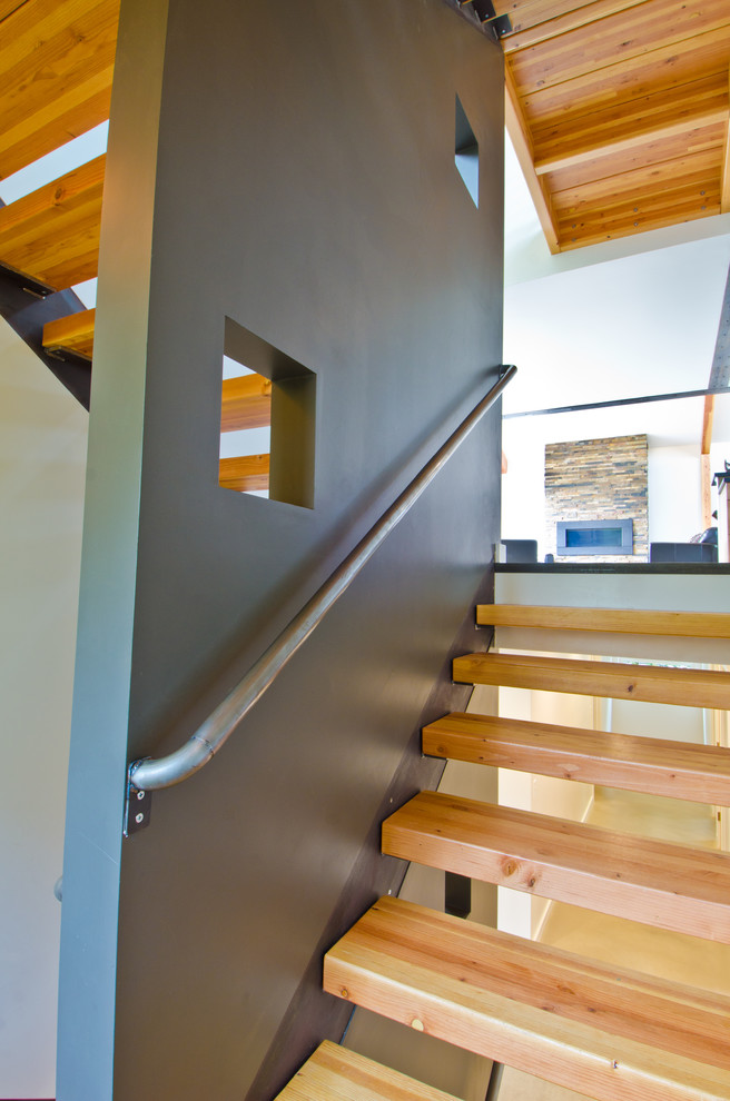 Foto de escalera en U moderna de tamaño medio sin contrahuella con escalones de madera