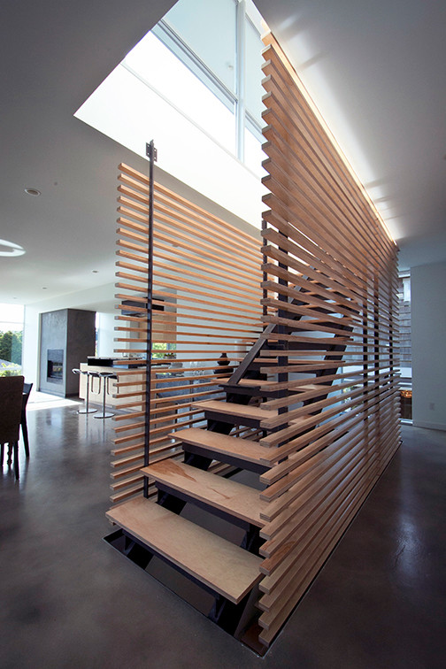 На фото: прямая лестница среднего размера в стиле модернизм с деревянными ступенями и деревянными перилами без подступенок