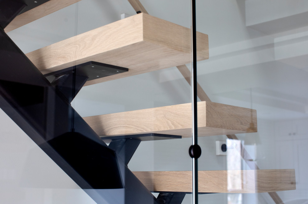 Modelo de escalera recta minimalista sin contrahuella con escalones de madera y barandilla de vidrio