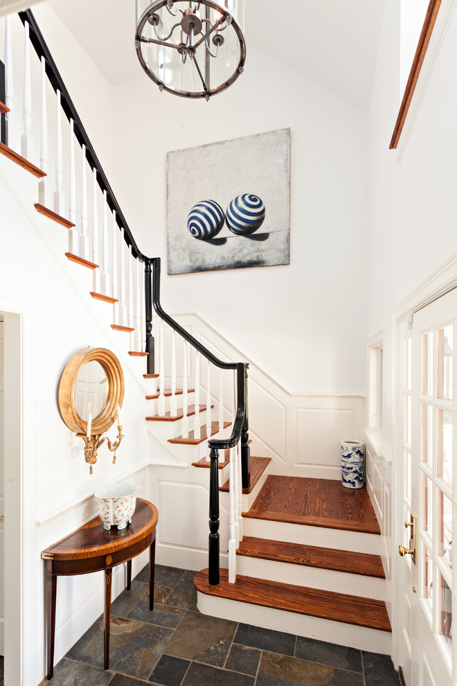 This is an example of a classic wood u-shaped staircase in Boston with painted wood risers.