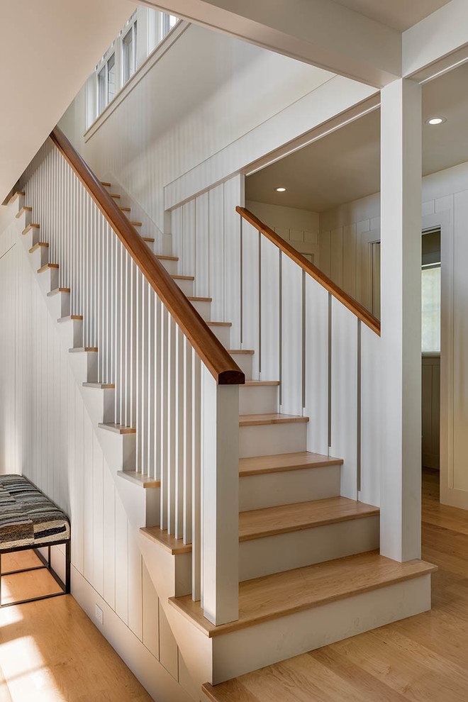 Пример оригинального дизайна: большая прямая лестница в морском стиле с деревянными ступенями и крашенными деревянными подступенками