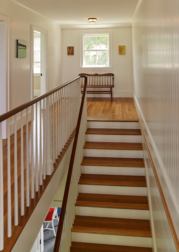 Mid-sized transitional wooden straight staircase photo in Portland Maine with painted risers
