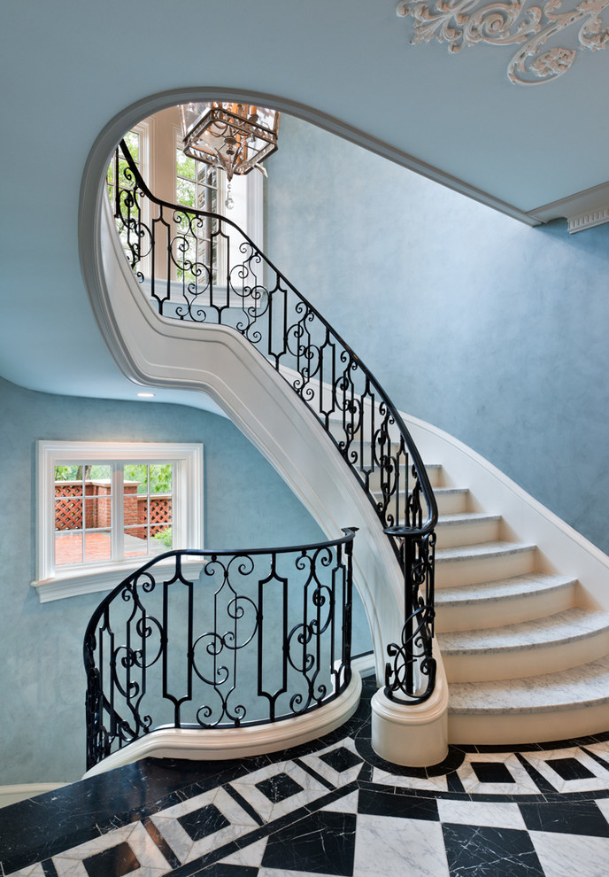 Идея дизайна: большая изогнутая деревянная лестница в классическом стиле с мраморными ступенями и металлическими перилами