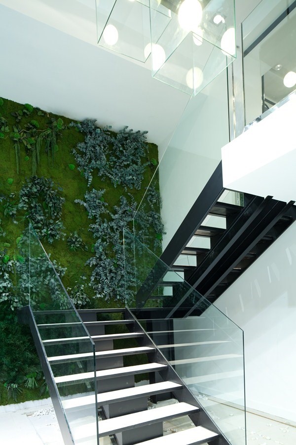 Photo of a medium sized contemporary metal u-shaped glass railing staircase in New York with open risers.