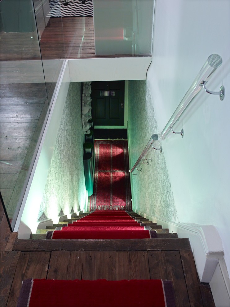 Medium sized classic carpeted straight staircase in London with wood risers.